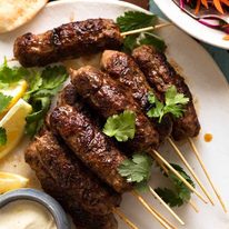 Lamb Koftas on a platter, ready to stuff into pita bread with minted salad and yogurt sauce