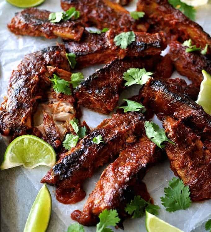 A tray of Oven Baked Ribs with Chipotle Barbecue Sauce scattered with cilantro