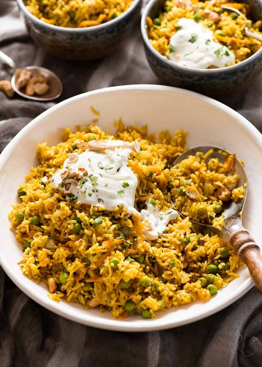 Curried Rice made with Basmati Rice in a white bowl being served