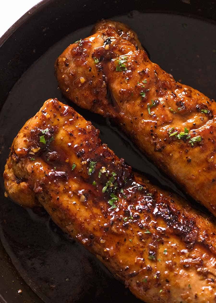 Overhead photo of two Honey Garlic Pork Tenderloin in a black skillet, fresh out of the oven