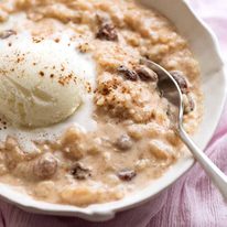 Close up of a bowl of Creamy Cinnamon Rice Pudding with vanilla ice cream