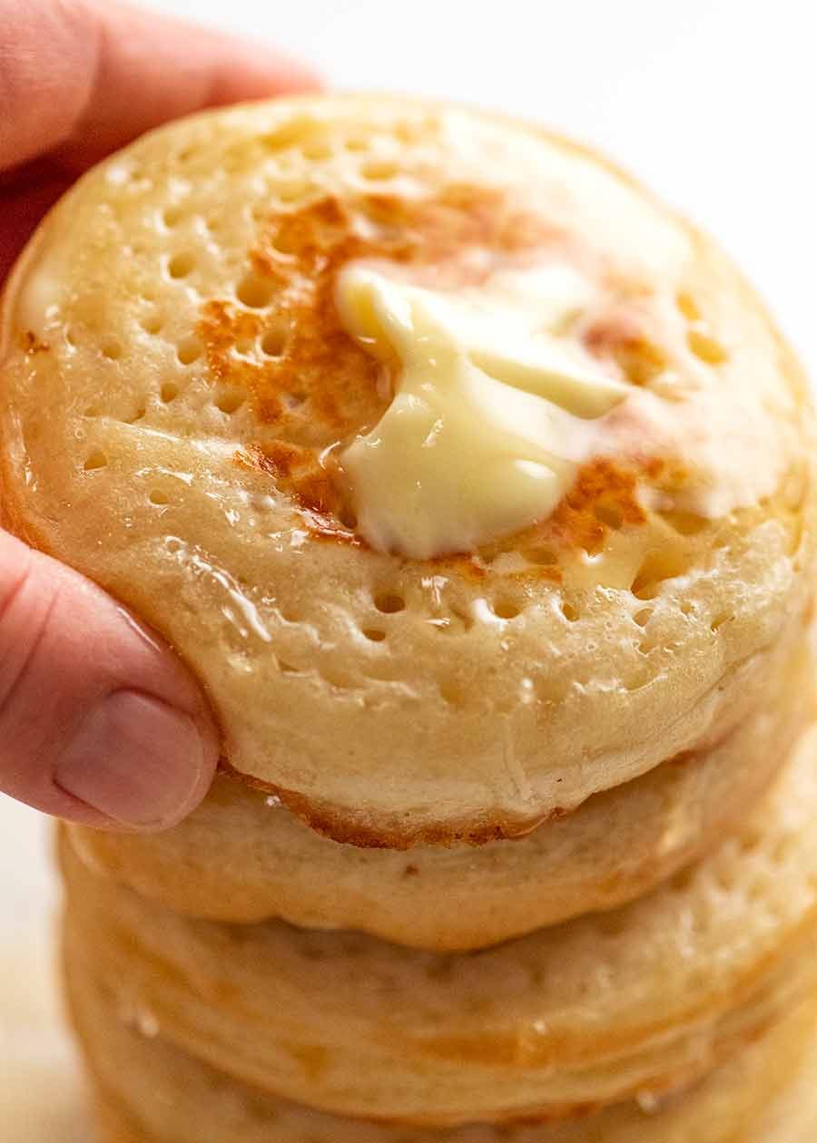 Hand picking up homemade crumpets