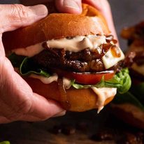Close up photo of hand holding Swiss Mushroom Burgers