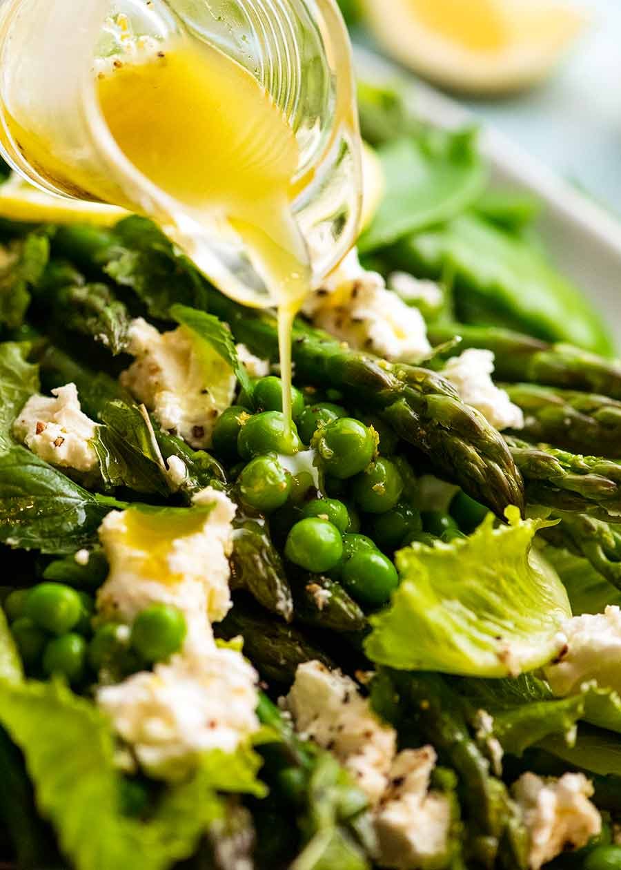 Drizzling lemon dressing over Spring Salad - with asparagus, peas, snow peas, baby cos lettuce (romaine) and goats cheese