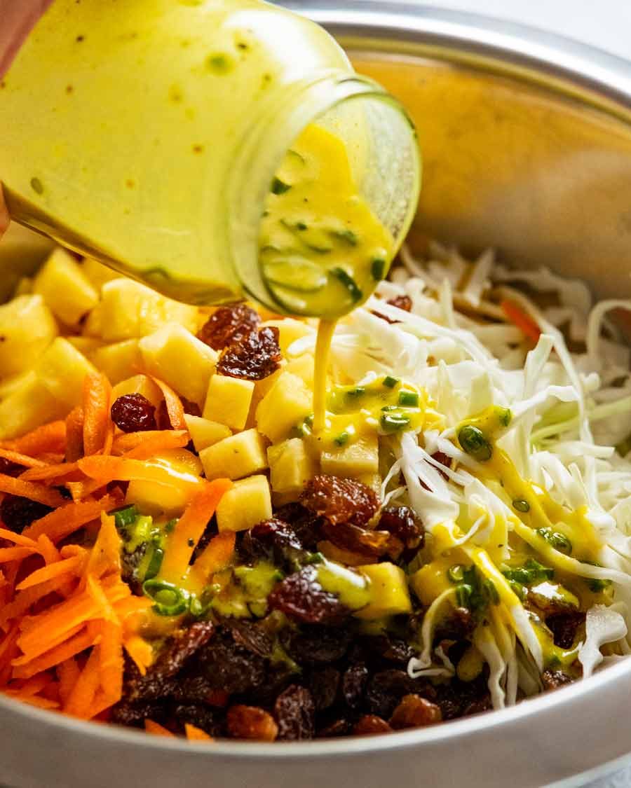 Pouring dressing over Jamaican Slaw